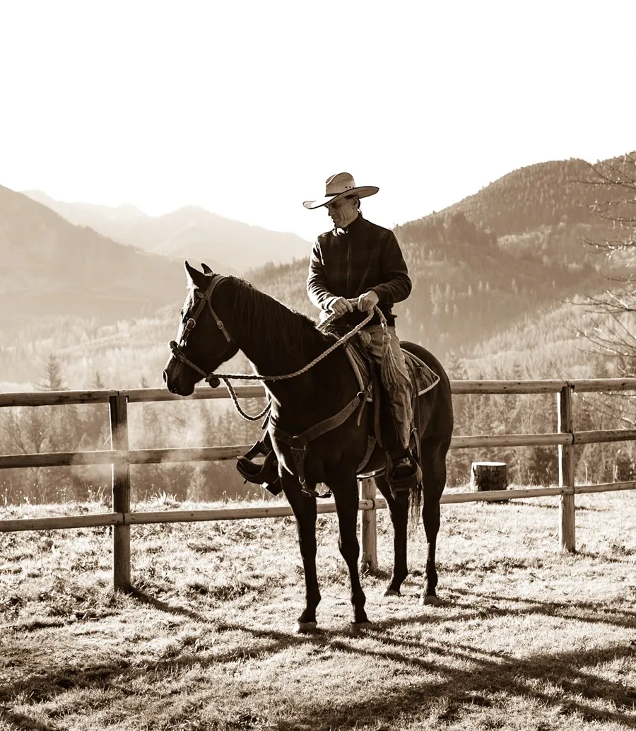 Pa on horseback at the ranch, mountains behind